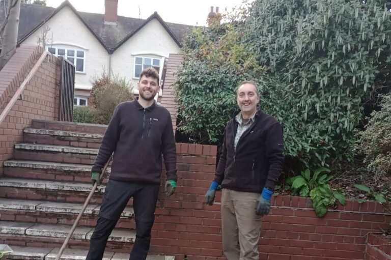 Two men stood with gardening tools