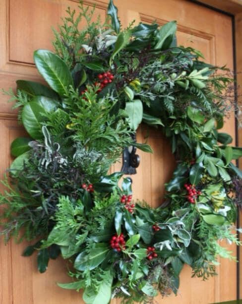 A green foliage wreath hanging on a door