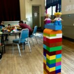 A Lego tower with two Lego people at the top